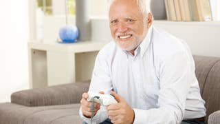 An old man with sadness in his eyes stares into the camera whilst holding an Xbox 360 controller