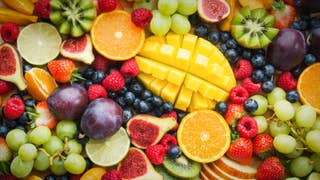 A photograph of a platter of fruit. There's all sorts here: plums, grapes, sliced oranges, limes, a pineapple that's very artfully cut. It doesn't look like that when I cut it. Kiwis. Strawberries. Raspberries. It's enough to make you salivate.