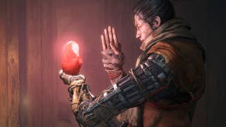 A samurai, side-on, holding what looks to be a glowing baby doll in their hand, and praying to it. They have a mechanical arm.